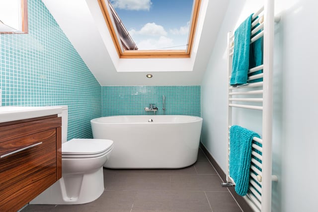 Enjoy a soak while watching the clouds or the night sky, in this bathroom's luxurious bath tub.