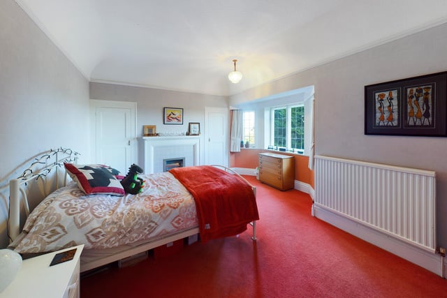 This bedroom has a fireplace and bay window, afgain with plenty of floor space.