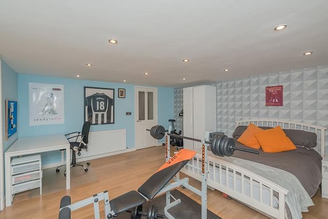 This bedroom has plenty of space for a desk unit and gym equipment.