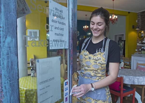 Elise Perron cleans the door handles at the Piecebox cafe in Polworth (Picture: Neil Hanna)