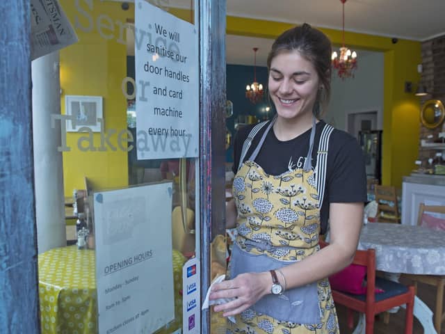 Elise Perron cleans the door handles at the Piecebox cafe in Polworth (Picture: Neil Hanna)
