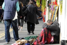 A homeless man on Edinburgh's Royal Mile bows his head (Picture: Lisa Ferguson)