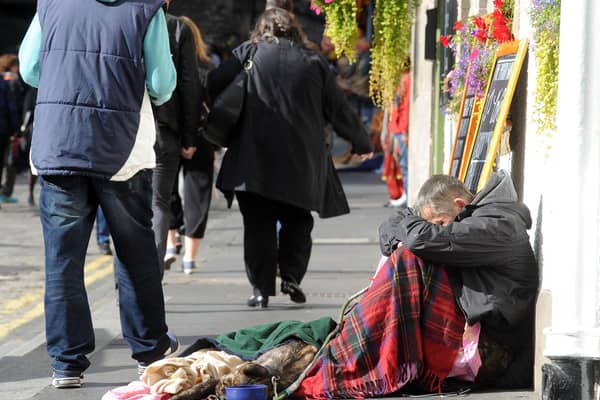 A homeless man on Edinburgh's Royal Mile bows his head (Picture: Lisa Ferguson)