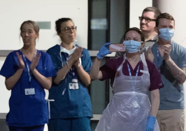 Medics join in the with the applause (Picture: Peter Byrne/PA Wire)