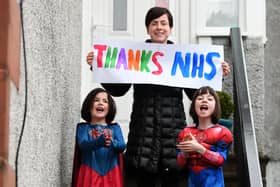 A family joins in the applause for the NHS in Glasgow (Picture: John Devlin)