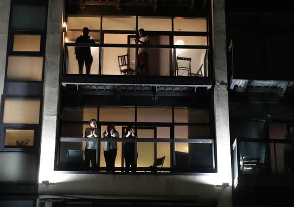 Glasgow residents take to their balconies to join in with the round of applause on 26 March (Picture: Andrew Milligan/PA Wire)