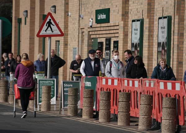 Customers social distancing in the queue outside a Morrisons supermarket (Picture: Victoria Jones/PA Wire)