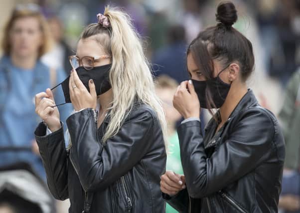 Shoppers put on face masks in Edinburgh's Princes Street earlier this month, when the public were being advised to do so. It is now mandatory to wear a face covering in shops. (Picture: Jane Barlow/PA Wire)