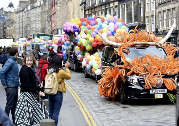 Big smiles from onlookers as last year's wildly decorated taxis head down the Royal Mile (Picture: Lisa Ferguson)