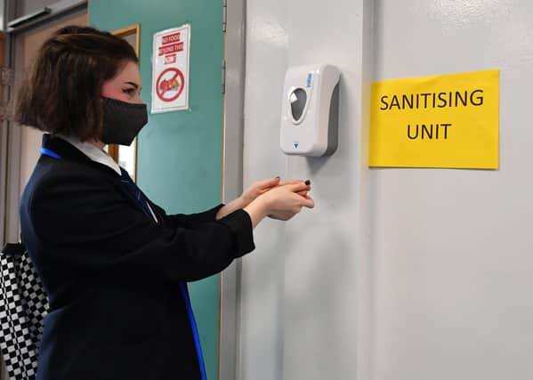 A pupil sanitises her hands in school (Picture: John Devlin)
