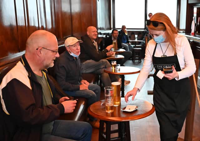 A waitress wears a mask as she works in the pub The Grill in Union Street , Aberdeen. Picture: Getty