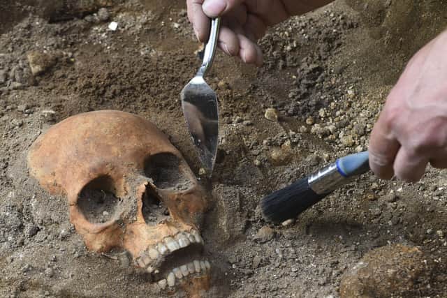 An archaeologist uncovers a skull dating back around 500 yearsin Leith (Picture: Lisa Ferguson)