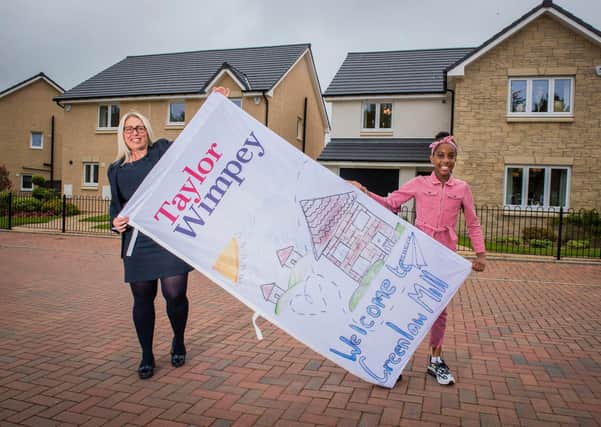 Precious Orjj, aged 10, pictured with her winning flag design and Taylor Wimpey East Scotland’s sales executive, Lyndsay Wood, at Greenlaw Mill in Penicuik. Picture Copyright Chris Watt.