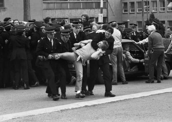 Four police officers struggle with a striking miner as clashes break out at Bilston Glen colliery in June 1984.
