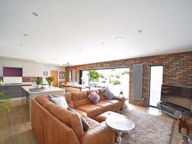 This open plan kitchen is located at the rear of the house with five casement fold out sliding doors that lead out to the spacious garden. The kitchen is fitted with polished quartz work surfaces, an island unit, underslung sink and breakfast bar. Appliances include twin built in Neff eye level ovens, a five place gas hob beneath a cooker hood, automatic dishwasher, microwave and fridge/freezer.
