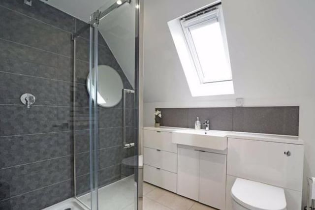 The en suite bathroom connecting to the master bedroom has a vanity wash basin with cupboards and a ceramic tiled shower cubicle with a sliding door.