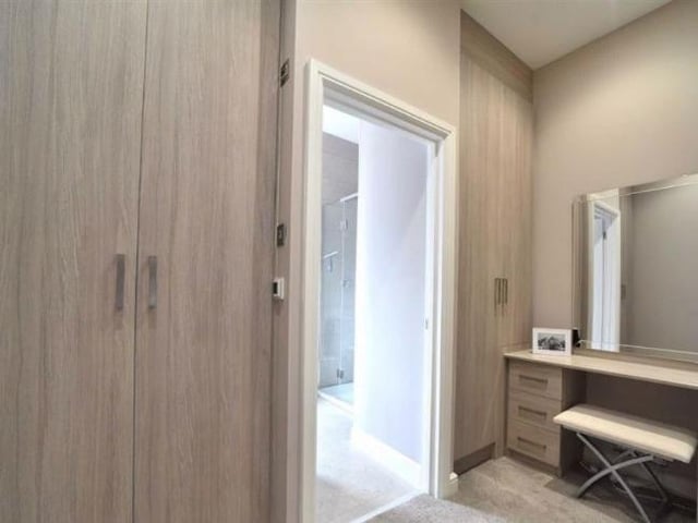 The dressing room has triple fitted wardrobes with shelving and hanging space, a heated towel rail as well as a dressing table. A door leads to the en suite bathroom.