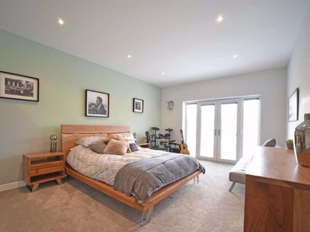 A very spacious double room with a high ceiling with LED downlighters and french doors opening to a glazed juliet balcony overlooking the rear garden.