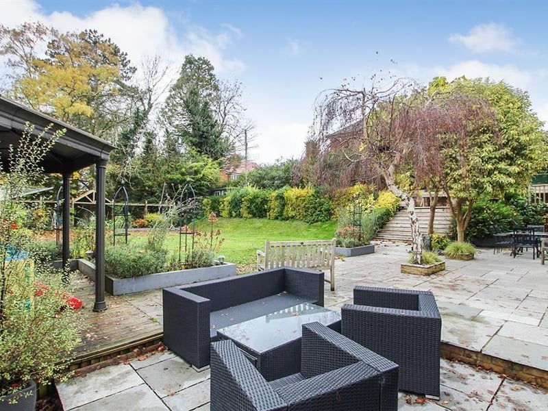 This vast rear garden contains a decked patio area with a gazebo, a greenhouse and a fenced off large lawn area