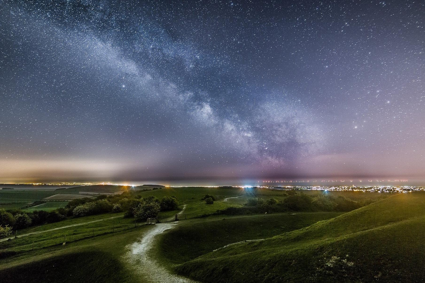 The milkyway above the lights of Worthing and Brighton from Cissbury Ring by Neil Jones SUS-220702-091031001
