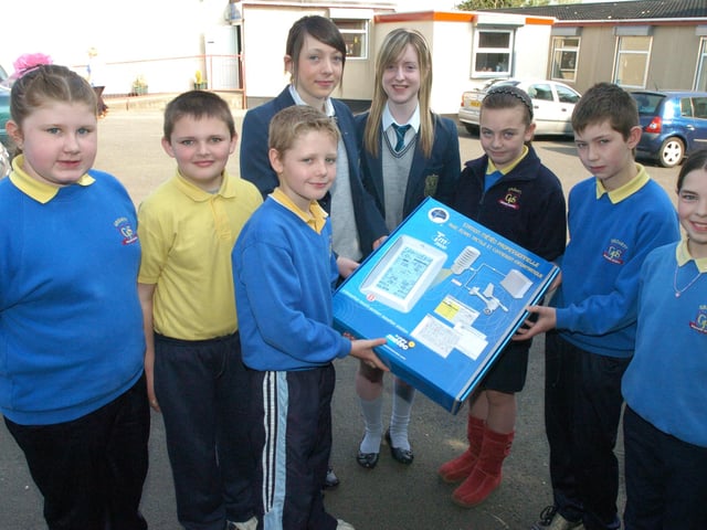 Orla McCann, left, and Emma Doherty from the Thornhill College Young Scientists Group present a weather station to children from Groarty Primary School when they visited to discuss the feasibilty of renewable energy generation from wind at schools, in conjunction with the Royal Society. Included, from left, Victoria Poole, Eamon Kyle, Faolan Hanna, Jordan Parke, Gordon Crockett, and Emma Wylie. (1205PG35)