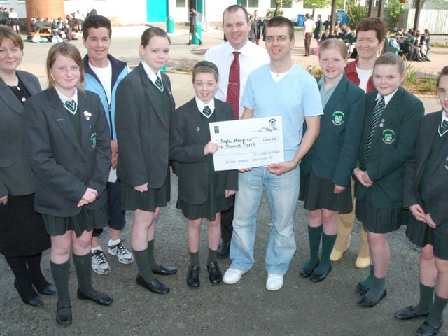 Niamh Bradley from Thornhill College presents her father Paul with a cheque for £1000, money raised by pupils who took part in a sponsored marathon walk to support Paul who ran the London Marathon for the Foyle Hospice.