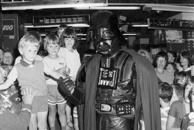 Darth Vader shakes hands with a little boy in the toy department of Jenners store in Edinburgh in July 1983.