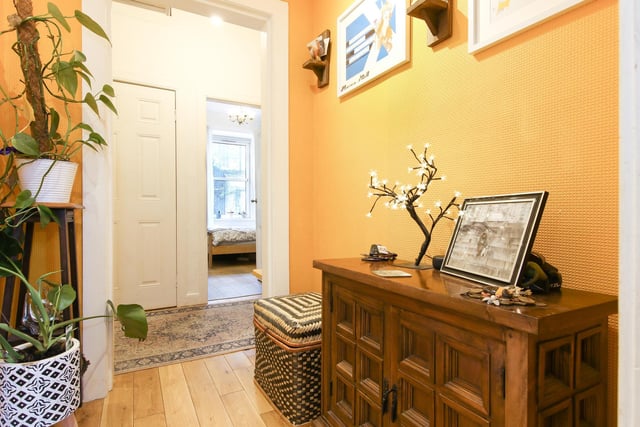 The flat is accessed via a communal door and a traditional shared stair. Its front door opens onto this generous entrance hall with high ceilings and timber effect flooring.