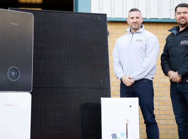 Edinburgh Boiler Company (EBC) managing director Mark Glasgow (right) and operations director Dougie Bell, alongside solar panels, boilers, an inverter and heat pumps.