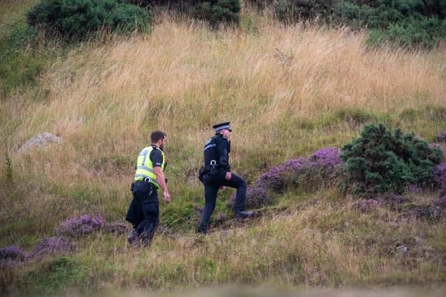 Police Officers at Arthur's Seat on Friday. A man has been arrested in connection with the death.