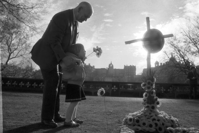 An elderly man and a little girl in the Garden of Remembrance in Princes Street Gardens Edinburgh, November 1989.