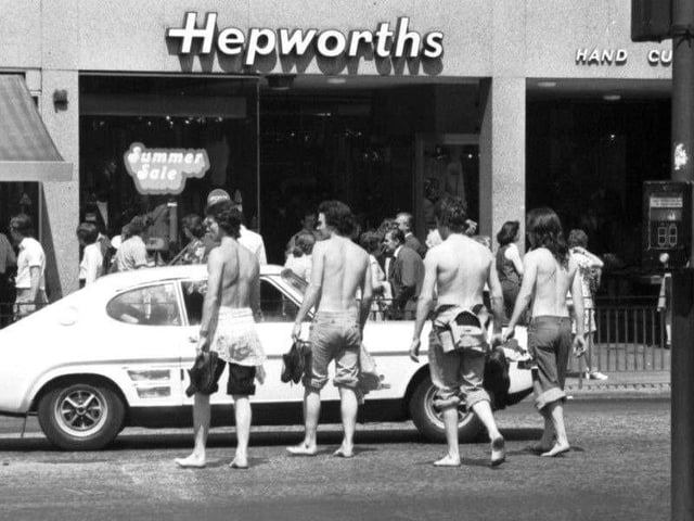 Teens stripped to the waist and in bare feet crossing Princes Street in summer 1976.