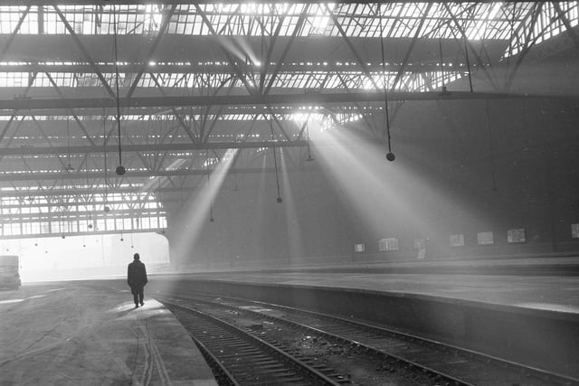 Rays of light pour through the canopy of the deserted Princes Street Station, which closed in 1965.