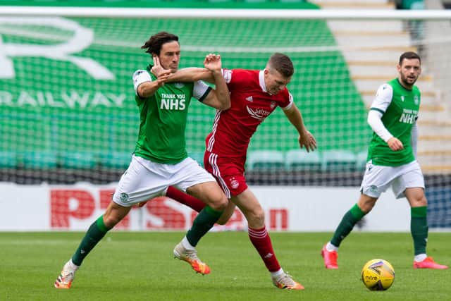 HIbs midfielder Joe Newell vies for the ball with Aberdeen counterpart Lewis Ferguson