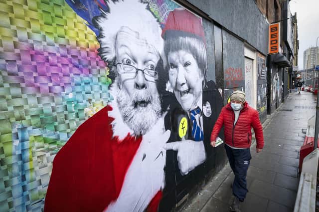 A member of the public walks past a poster featuring Father Christmas and Wee Jimmy Krankie on Leith Walk