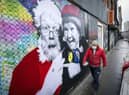 A member of the public walks past a poster featuring Father Christmas and Wee Jimmy Krankie on Leith Walk
