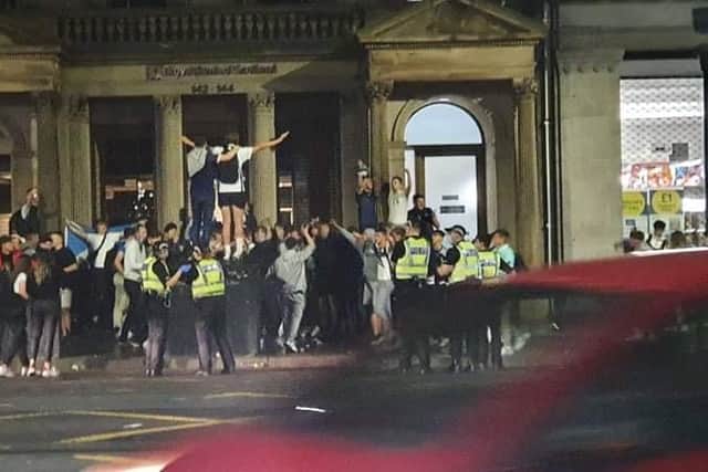 Police seen approaching crowds of football fans celebrating on Prince Street in Edinburgh on Friday night (Photo: William Scally).