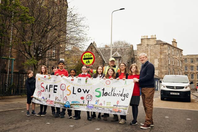 Stockbridge Primary School pupils are calling for Edinburgh's streets to be made safer for all. Picture with school road safety guard Willie Grieve and Edinburgh Central MSP Angus Robertson (Picture: Pete Dibdin)