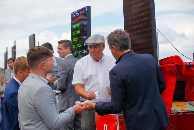 One racegoer hopes luck is on his side as he places a bet on the first race of the day.