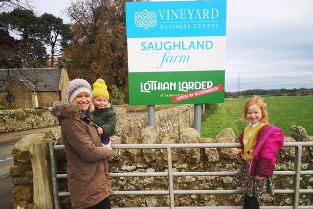 Eilidh and her kids at farm signpost