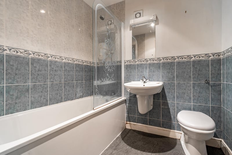 The family bathroom with a white three-piece suite comprising WC, wash hand basin and bath with shower.