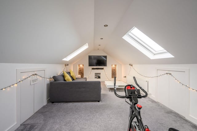 The attic/ TV room is accessed via a drop-down ladder, featuring a dual-aspect outlook with Velux windows and benefits from good storage provisions within the eaves.