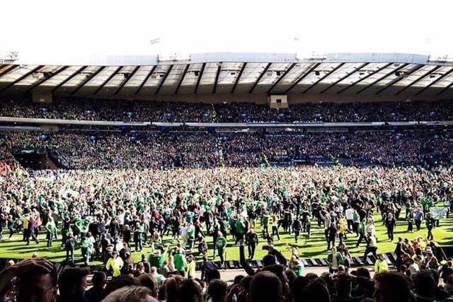 Hibs fans stream onto the pitch at the full time whistle. Photo: Florence Donaldson