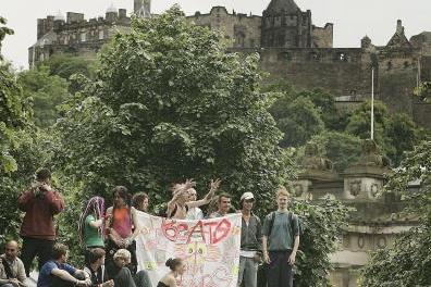 Protesters stand an a bus shelter with Edinburgh Castle in the background