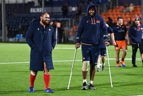 Viliame Mata, right, leaves the field on crutches with Edinburgh team-mate Lee-Roy Atalifo.  (Photo by Paul Devlin / SNS Group)