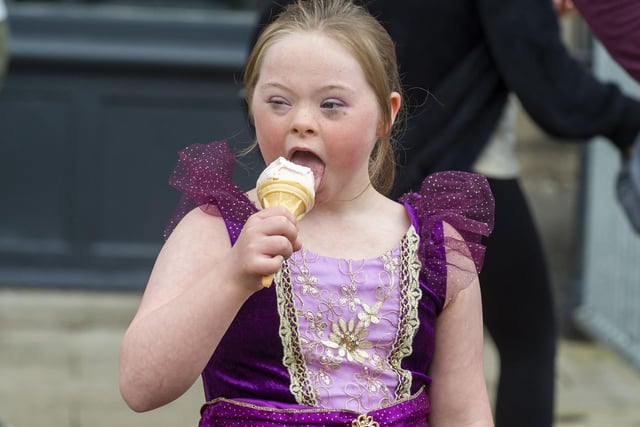 This little girl, dressed as Rapunzel from Tangled, enjoyed an ice cream as she watched the parade.