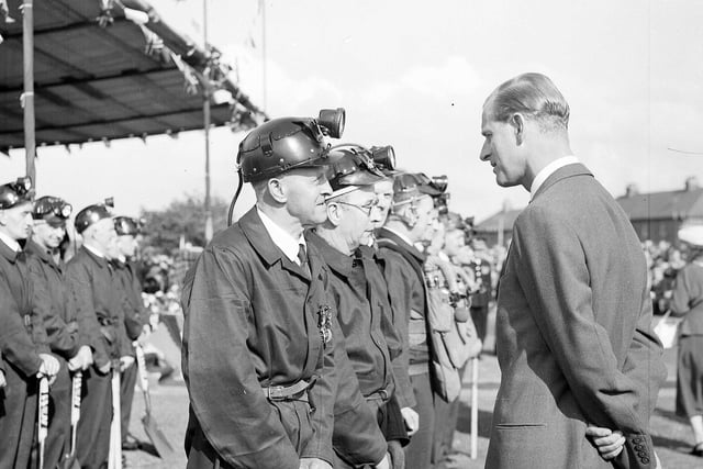 The Duke of Edinburgh talking to miners during a royal tour of Scotland in July 1956.