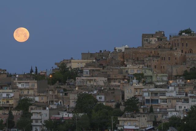 A full moon rises above the historical city centre of Mardin, famous with its stone houses, in southeastern Turkey, early Monday, May 16, 2022. (AP Photo/Emrah Gurel)