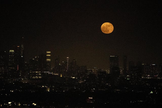 A supermoon rises above the skyline of downtown Los Angeles, Tuesday, June 14, 2022. The moon reached its full stage on Tuesday, during a phenomenon known as a supermoon because of its proximity to Earth, and it is also labelled as the "Strawberry Moon" because it is the full moon at strawberry harvest time. (AP Photo/Ringo H.W. Chiu)