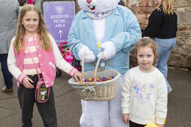 Poppy Stevenson, nine, and Ella Dean, five, smile with the Easter bunny.